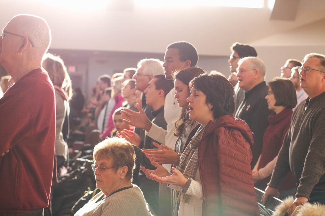 People in the church are worshipping, attentively listening to the word of God.